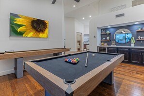 Game room features pool and shuffleboard tables plus a wet bar with a wine fridge.