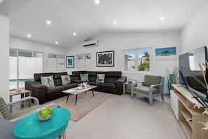 Natural light pours in through large windows, while a Smart TV with Netflix and cozy swivel chairs make it the ideal spot for movie nights, reading, or gathering with loved ones.