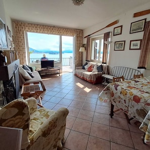 Living room with dining table, armchair, 2 sofas, TV and DVD, tea table