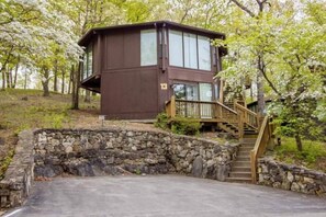 This modern elevated home offers a unique "treetop" living experience, blending seamlessly with the surrounding lush natural landscape. Multiple large windows allow for abundant natural light and scenic views, making this a bright and inviting retreat.