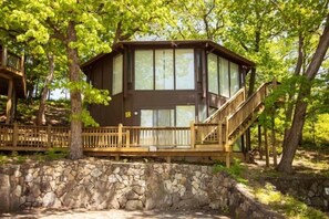 This modern elevated home offers a unique "treetop" living experience, blending seamlessly with the surrounding lush natural landscape. Multiple large windows allow for abundant natural light and scenic views, making this a bright and inviting retreat.