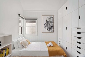 Cosy king single bedroom featuring a spacious cabinet and a sleek work desk — perfect for both rest and productivity.