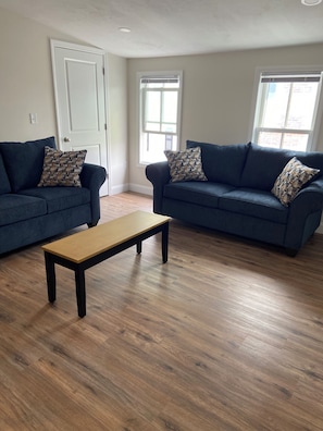Bright and comfy living room with smart TV, AC and Wi-Fi.