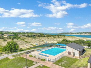 Community pool with a view of Lake Travis in the background