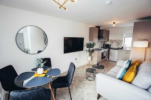 Lounge with wall-mounted TV, reading lamps, and decor accents