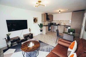 Lounge with wall-mounted TV, reading lamps, and decor accents