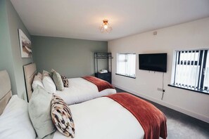 Bedroom with king-size bed & single bed, hotel-quality bedding, and clothes storage