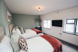 Bedroom with king-size bed & single bed, hotel-quality bedding, and clothes storage