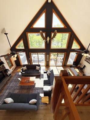 Main living room with 25' ceilings, chalet windows & huge entertaining space.