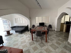 Comedor (mesa con 6 sillas, cómoda con tv, sala de estar con sillón y pequeño centro de mesa)