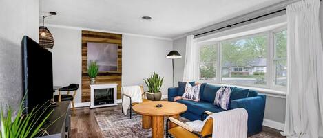 Stylish living area with natural light & modern furnishings.
Couch is situated in front of a large bay window looking out onto mature tree-lined, quiet street.