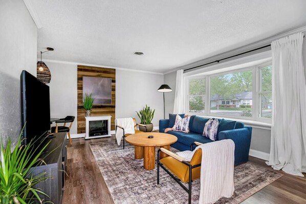 Stylish living area with natural light & modern furnishings. 
Couch is situated in front of a large bay window looking out onto mature tree-lined, quiet street.