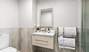 Bright, modern bathroom with plush towels and lush toiletries

