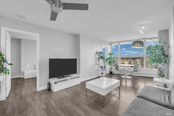 Bright and modern, this stylish living space features sleek furniture, vibrant greenery, and floor-to-ceiling windows with breathtaking city views. The minimalist design and natural light create a perfect blend of comfort and sophistication.