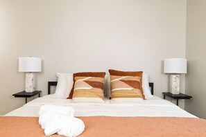 Primary bedroom with king bed, attached bathroom and ceiling fan.