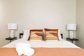 Primary bedroom with king bed, attached bathroom and ceiling fan.