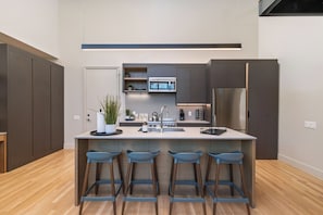 Kitchen is fully stocked and ready to use, with seating for 4 at the island.