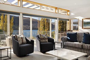 Spacious family-friendly living area with indoor-outdoor flow onto large decks overlooking Lake Wakatipu.

