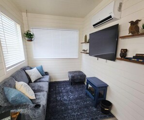 Cozy living area in luxury container home Fredericksburg - smart TV, plush seating, AC comfort for wine country guests exploring Texas Hill Country wineries and downtown attractions.