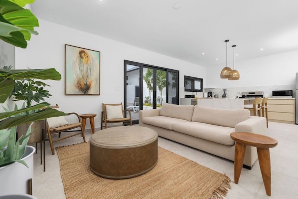 Open-concept living room and kitchen with natural light, modern design, and space for the whole family to relax.