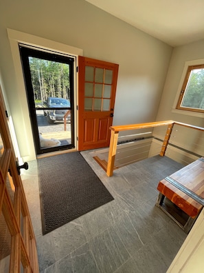 Main Entrance to the mudroom with a bench and coat rack to offload your things!