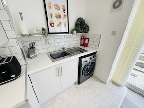 Fully equipped kitchen with cooker and hop, washing machine, toaster, kettle,