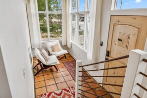 Warm, terra-cotta tile and cozy lounge chairs make for the perfect place to enjoy your morning brews and small town views.