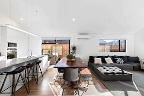 Cook, dine, and unwind in this stylish open-plan kitchen with quality appliances and breakfast bar seating. (furniture to be updated post-June 16th)