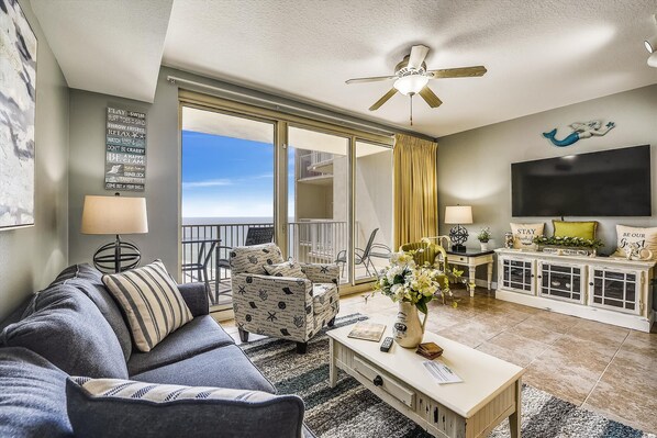 The spacious and beautifully furnished living room with mounted TV and sleeper sofa