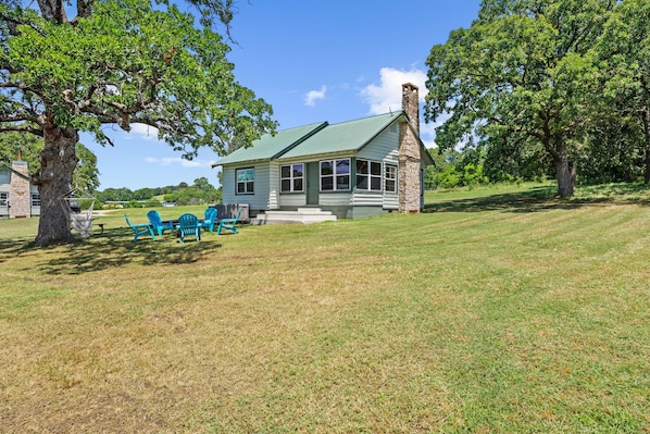 Spacious shaded outdoor area surrounded by trees - ideal for gathering, lounging, or enjoying nature