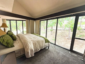 Wake up to a wall of green—this bedroom offers peaceful views of the surrounding woods