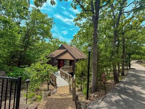 This modern elevated home offers a unique "treetop" living experience, blending seamlessly with the surrounding lush natural landscape. Multiple large windows allow for abundant natural light and scenic views, making this a bright and inviting retreat.