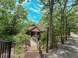 This modern elevated home offers a unique "treetop" living experience, blending seamlessly with the surrounding lush natural landscape. Multiple large windows allow for abundant natural light and scenic views, making this a bright and inviting retreat.