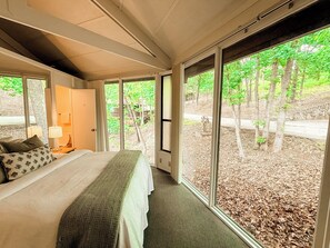 Wake up to a wall of green—this bedroom offers peaceful views of the surrounding woods