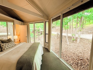 Wake up to a wall of green—this bedroom offers peaceful views of the surrounding woods