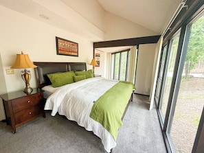 Let the forest be your backdrop—cozy up in this serene and naturally lit bedroom retreat.