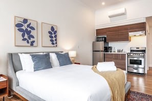 Sleep easy in a queen bed wrapped in hotel-grade linens, flanked by warm lighting and botanical prints. An oasis of calm above downtown Stratford. #KingBed #LoftLiving #StudioStay #BoutiqueAirbnb #StratfordOntario #JunoLofts #DesignBnb