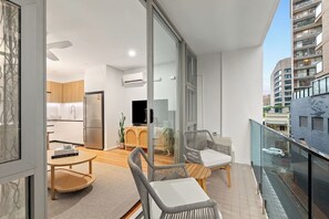 Step outside to the private balcony, an urban retreat with modern chairs and a small table, ideal for unwinding with a book or enjoying the fresh air amid the city’s buzz.