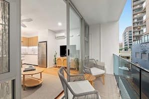 Step outside to the private balcony, an urban retreat with modern chairs and a small table, ideal for unwinding with a book or enjoying the fresh air amid the city’s buzz.