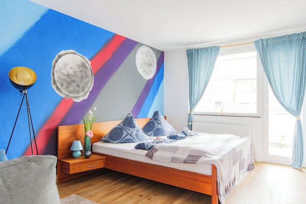 Gemütliches Schlafzimmer mit Doppelbett und Weltraum-Wanddesign