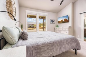 Main Bedroom with Cali King bed, rocking chair, TV, private bathroom attached.