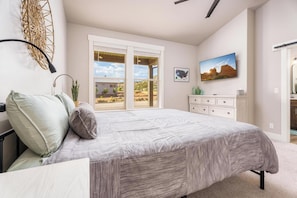 Main Bedroom with Cali King bed, rocking chair, TV, private bathroom attached.