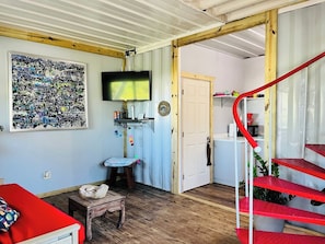 View of the living room area, full bathroom & kitchen.