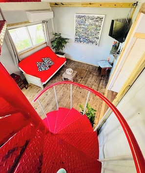 View from the second floor to our living room. Tv with WiFi, futon, full bathroom, kitchen & dining room area.