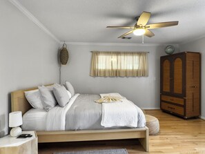 Cozy king bed in main bedroom with ceiling fan for warm evenings.