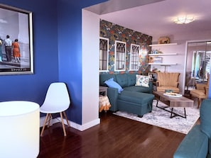 An open concept living space leads from one family room with a TV, into a living room set up for board games.