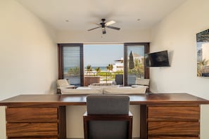 This bedroom features a built-in desk, and sweeping ocean views from the private balcony. Ideal for remote work or a tranquil retreat.