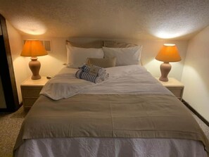 Plush bedding, soft lighting, and serene surroundings make this bedroom a guest favorite.