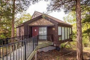 This modern elevated home offers a unique "treetop" living experience, blending seamlessly with the surrounding lush natural landscape. Multiple large windows allow for abundant natural light and scenic views, making this a bright and inviting retreat.