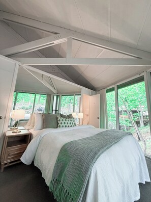 Wake up to a wall of green—this bedroom offers peaceful views of the surrounding woods
